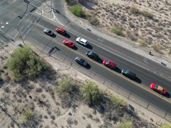 an overhead view of an intersection with cars with a person sitting near the intersection in a lawn chair