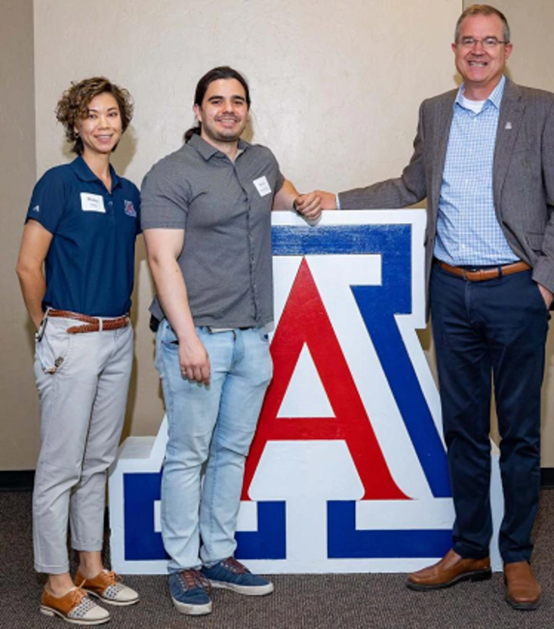 three people standing in front of Univ. of Arizona block A