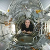 An older man floats inside a space vehicle.