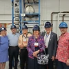 group of people wearing hard hats and safety goggle, standing in lab setting